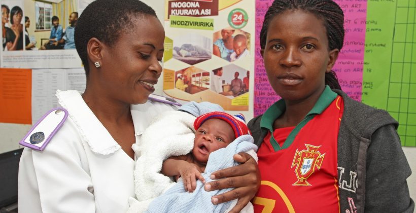 Zimbabwean midwife holding a woman's baby.