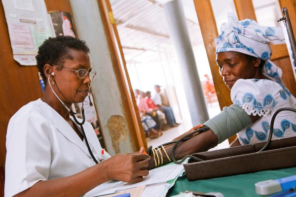 Nurse Oby Osigwe conducting triage with a patient at Saint Mary catholic hospital in Abuja, one of the hospitals benefiting from NACA support in Nigeria.
